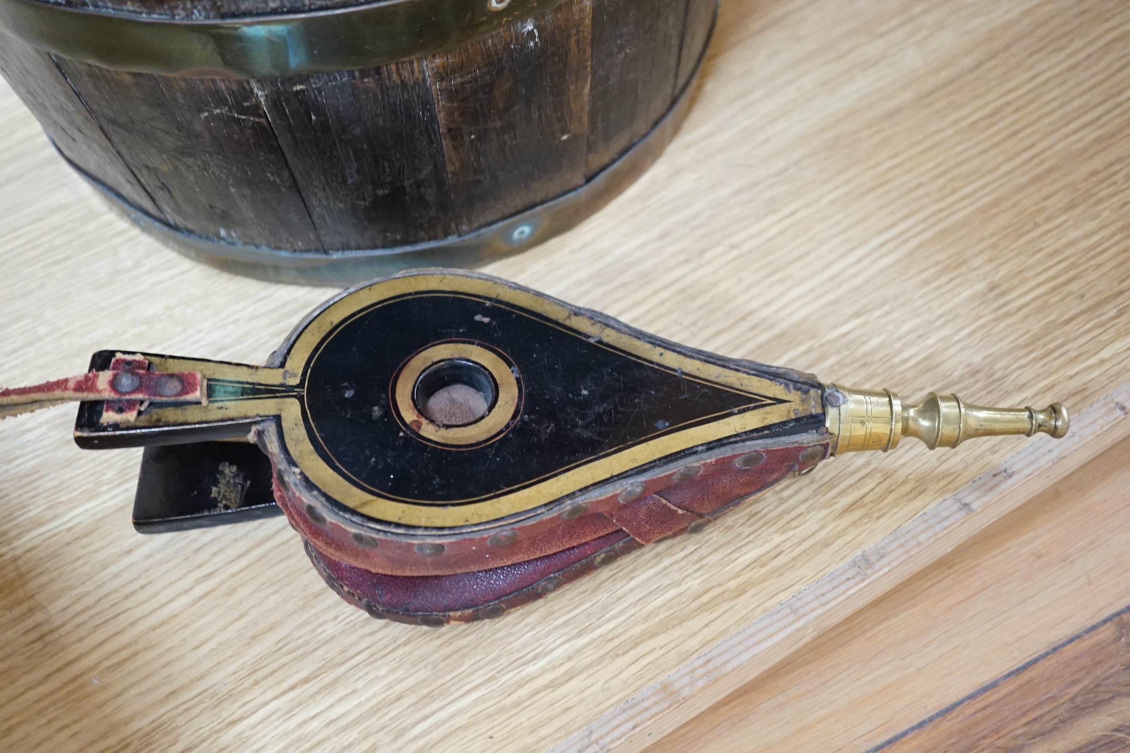 A coopered brass bound oak bucket and a small pair of lacquered bellows